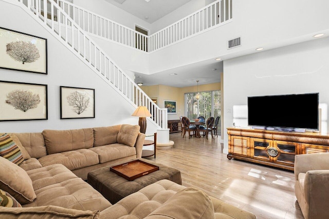 living room with a high ceiling and light hardwood / wood-style floors