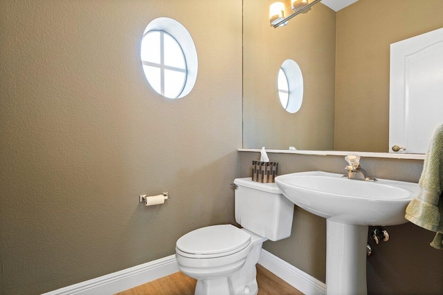 bathroom with toilet and hardwood / wood-style flooring