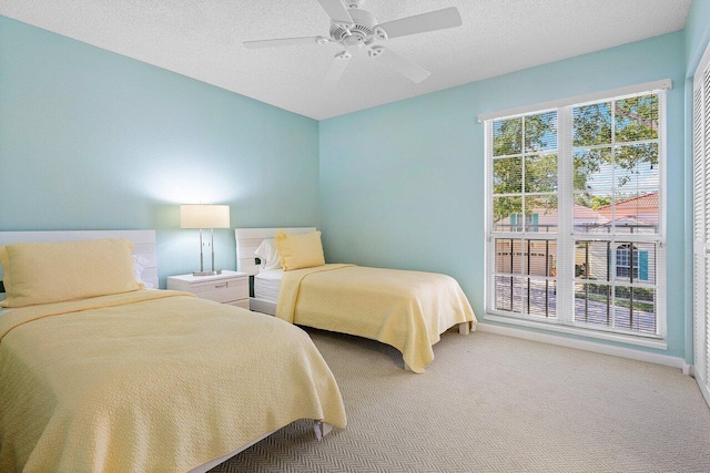 carpeted bedroom with ceiling fan and a textured ceiling