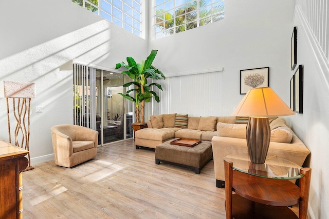 living room featuring a high ceiling and light hardwood / wood-style floors