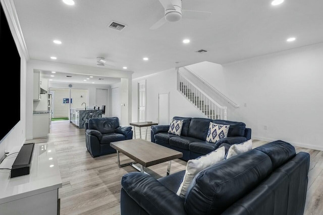 living room with sink, ceiling fan, ornamental molding, and light hardwood / wood-style floors