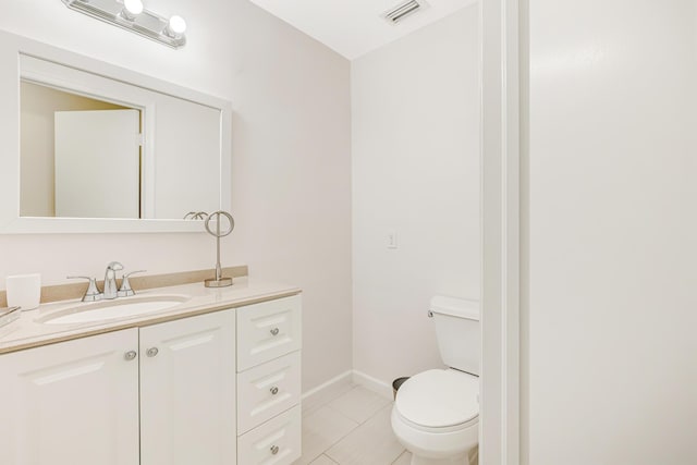 bathroom with visible vents, toilet, vanity, tile patterned flooring, and baseboards