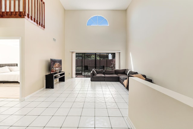 tiled living room featuring a high ceiling