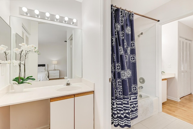 bathroom with tile patterned floors, vanity, shower / bath combo with shower curtain, and ensuite bathroom