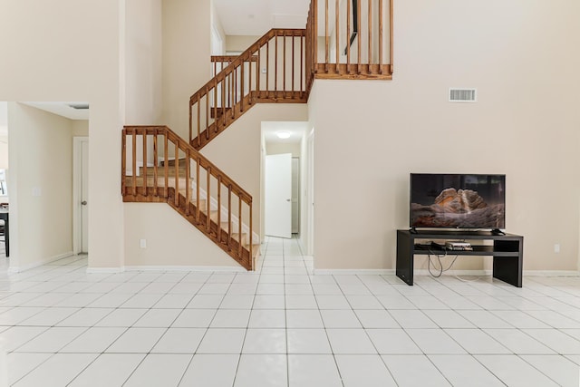 interior space with tile patterned floors and a towering ceiling