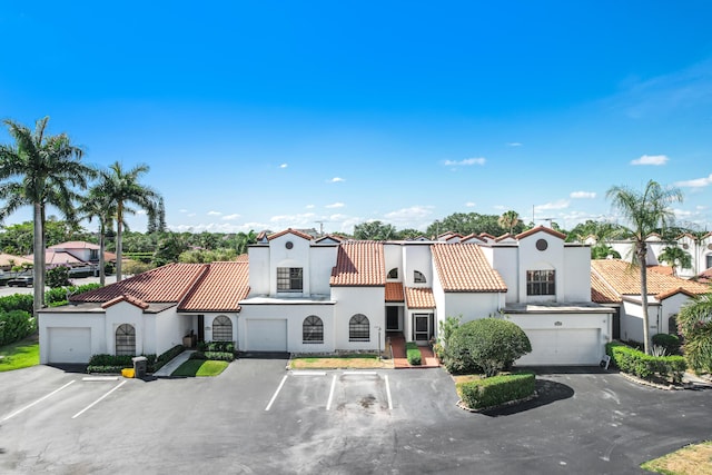 mediterranean / spanish-style house with a residential view, a tiled roof, and stucco siding