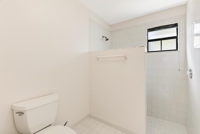 bathroom with a tile shower, tile patterned floors, and toilet