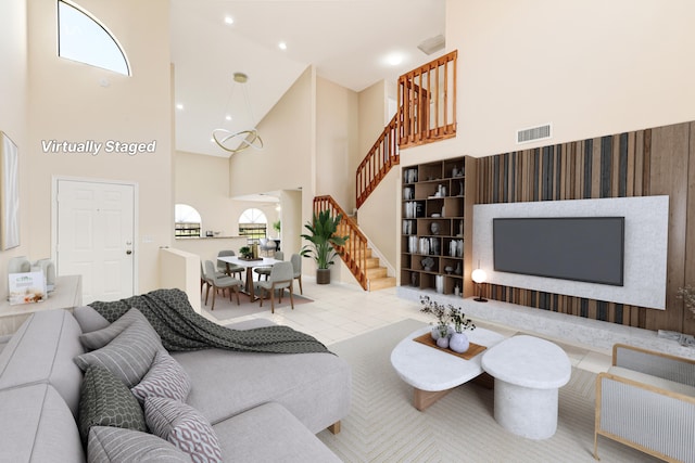 living room with light tile patterned flooring, recessed lighting, a towering ceiling, visible vents, and stairway