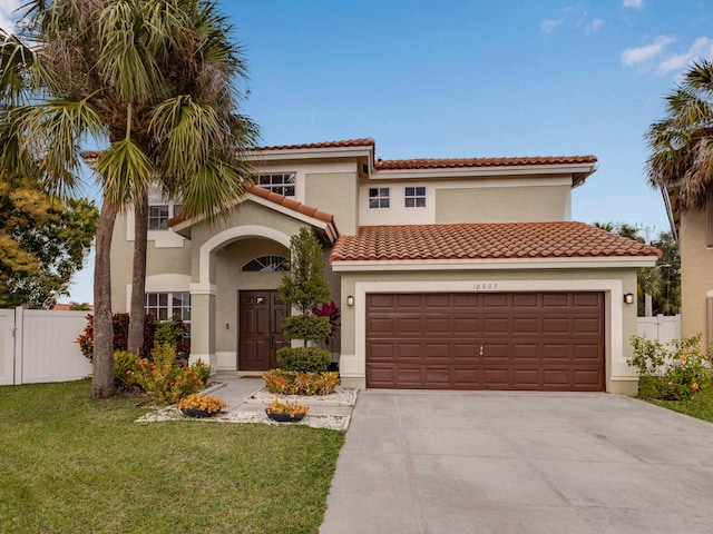 mediterranean / spanish home with a garage and a front lawn