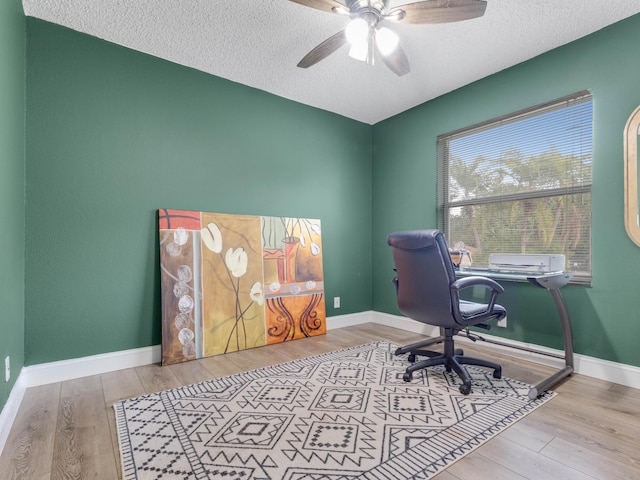 office space featuring a textured ceiling, light hardwood / wood-style floors, and ceiling fan