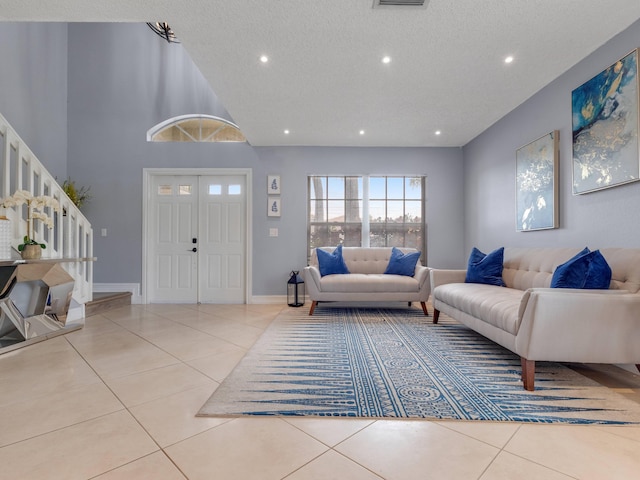 tiled living room with a towering ceiling and a textured ceiling