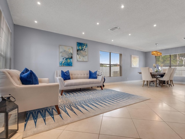 living room featuring plenty of natural light, light tile patterned flooring, and a textured ceiling