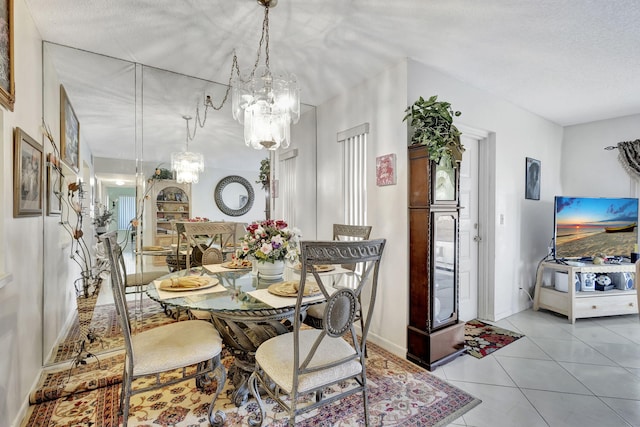 dining room with a notable chandelier, light tile patterned floors, and a textured ceiling