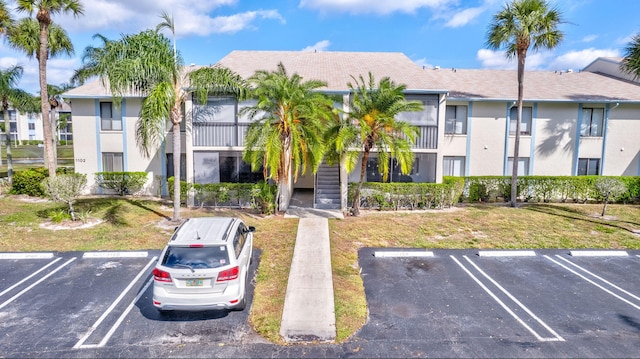 1102 Greenpine Blvd Unit A1, West Palm Beach, FL 33409 - view of property featuring uncovered parking and stairway
