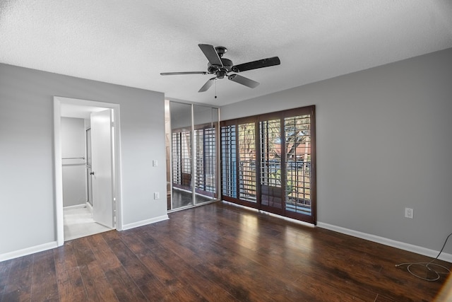 unfurnished room with ceiling fan, dark wood-type flooring, and a textured ceiling