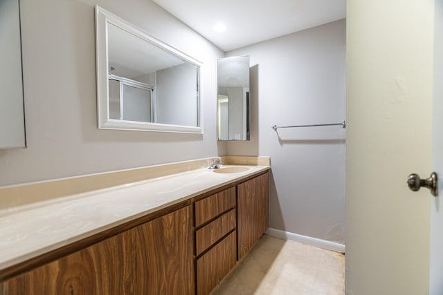 full bath with vanity, an enclosed shower, and tile patterned flooring