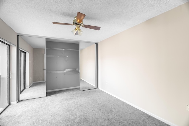 unfurnished bedroom featuring carpet flooring, ceiling fan, a closet, and a textured ceiling