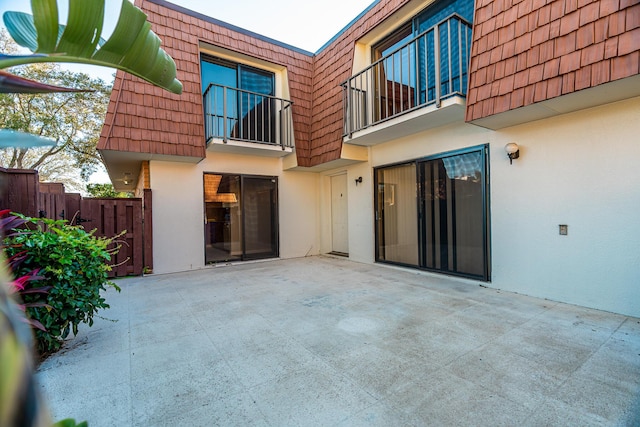 view of patio with a balcony and fence