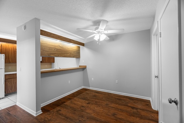 spare room with ceiling fan, a textured ceiling, and hardwood / wood-style flooring