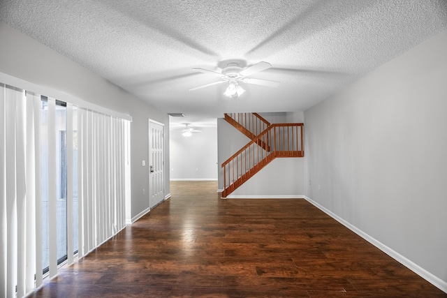 interior space with a ceiling fan, a textured ceiling, wood finished floors, stairway, and baseboards