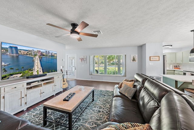 living room with hardwood / wood-style flooring, a textured ceiling, and ceiling fan