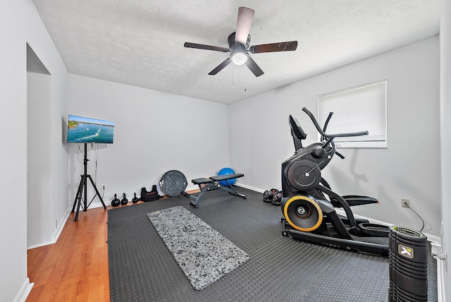 workout room featuring hardwood / wood-style flooring, ceiling fan, and a textured ceiling