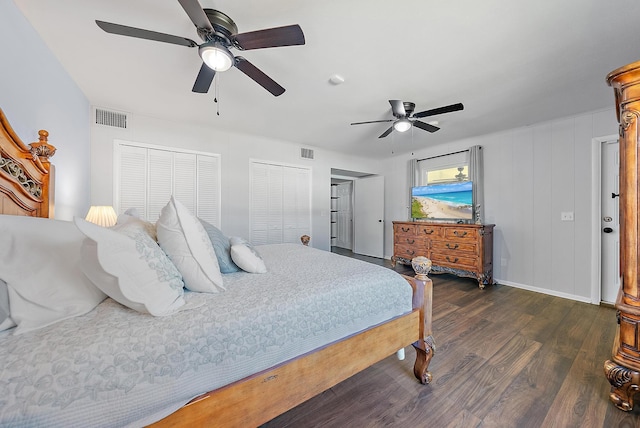 bedroom featuring two closets, dark wood-type flooring, and ceiling fan