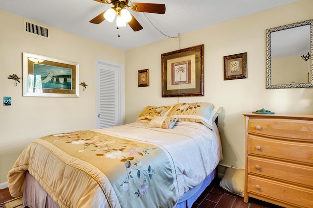 bedroom with ceiling fan, dark hardwood / wood-style flooring, and a closet