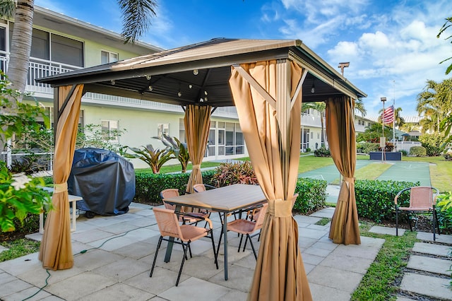 view of patio / terrace with a gazebo, basketball hoop, and grilling area