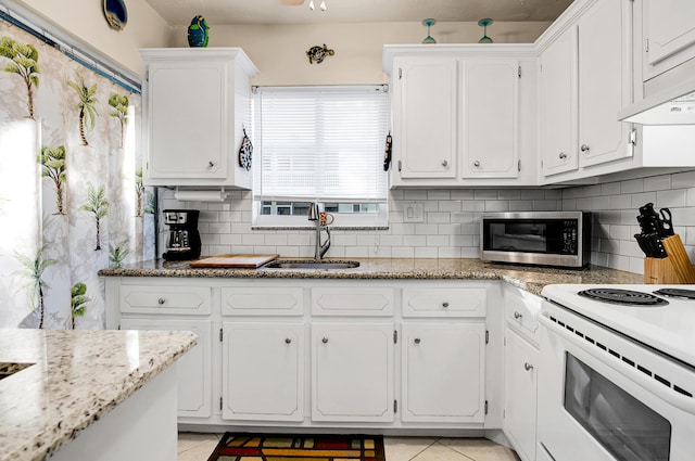 kitchen featuring white cabinetry, sink, white electric range, light stone counters, and light tile patterned flooring