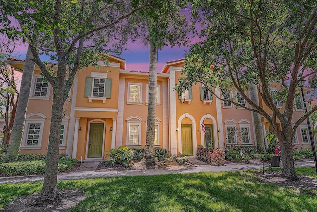 mediterranean / spanish house featuring a lawn