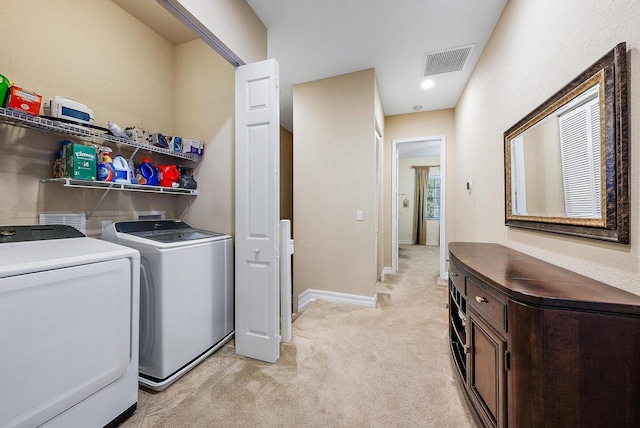 laundry room with separate washer and dryer and light colored carpet