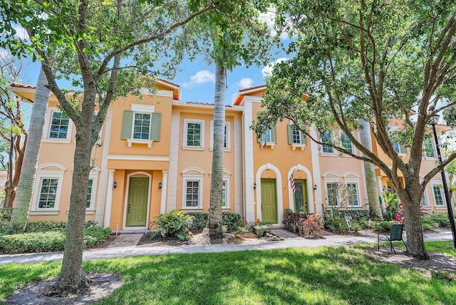 mediterranean / spanish house featuring a front lawn