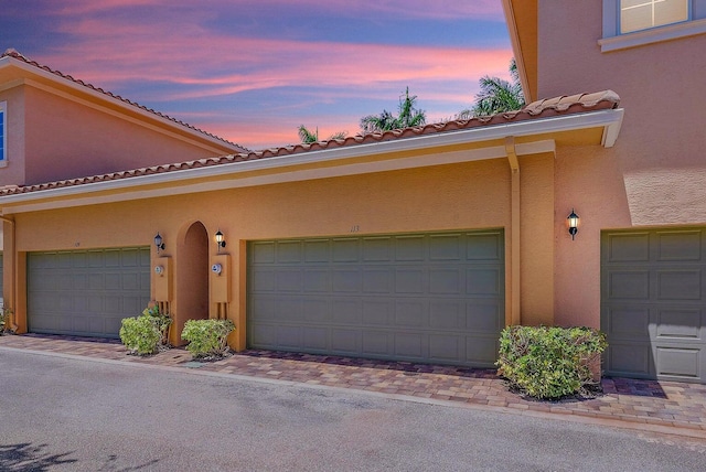 view of garage at dusk