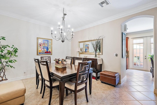 tiled dining area featuring ornamental molding and a chandelier