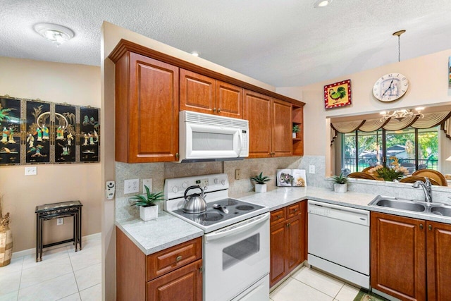 kitchen featuring pendant lighting, white appliances, an inviting chandelier, sink, and light tile patterned flooring