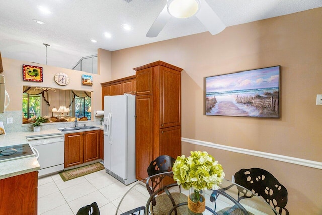 kitchen featuring a textured ceiling, white appliances, ceiling fan, sink, and light tile patterned flooring