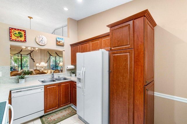 kitchen featuring white appliances, an inviting chandelier, sink, a textured ceiling, and light tile patterned flooring