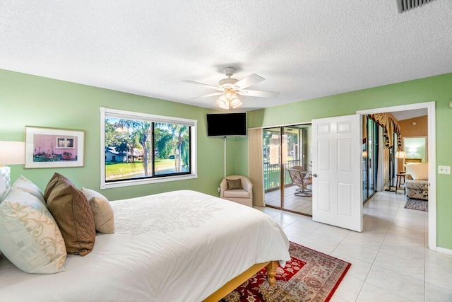 tiled bedroom with ceiling fan, a textured ceiling, and access to outside