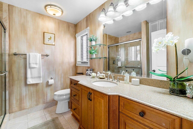 bathroom featuring tile patterned floors, vanity, toilet, and an enclosed shower