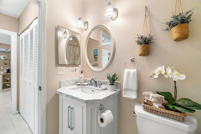 bathroom featuring tile patterned flooring, vanity, and toilet