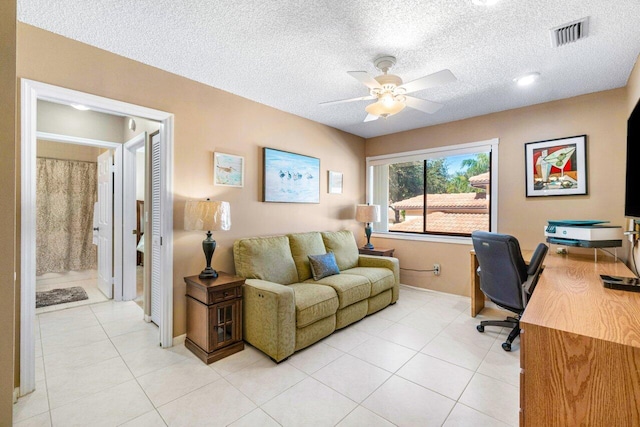 office area featuring ceiling fan, light tile patterned floors, and a textured ceiling