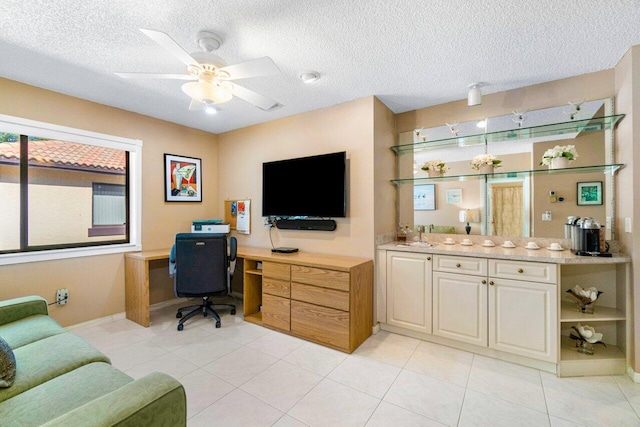 tiled home office featuring ceiling fan and a textured ceiling