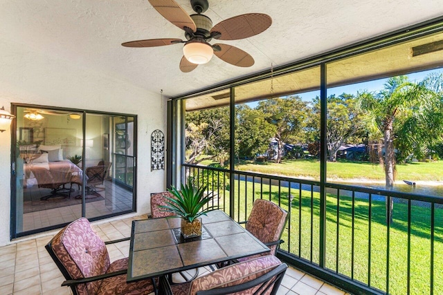 sunroom / solarium with ceiling fan and vaulted ceiling