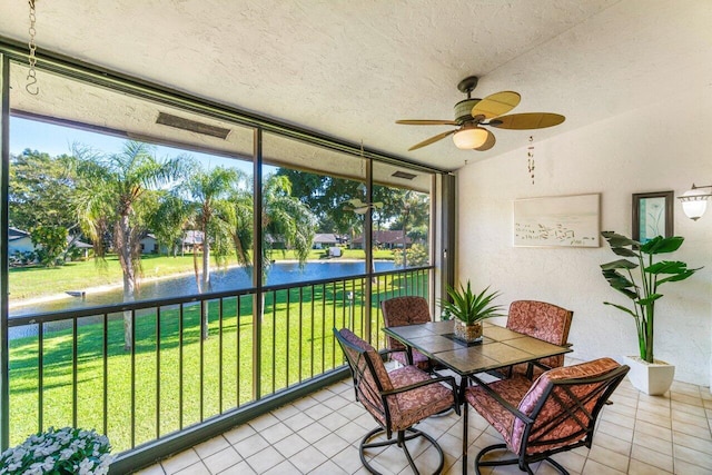 sunroom with a water view and ceiling fan