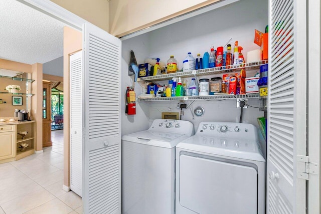 washroom with light tile patterned floors, a textured ceiling, and independent washer and dryer