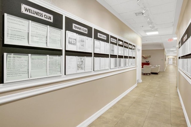 hall featuring light tile patterned floors and track lighting