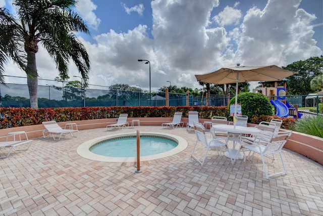 view of pool with a patio area and a hot tub