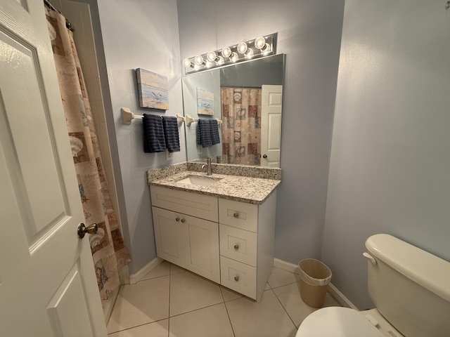 bathroom with toilet, vanity, and tile patterned floors