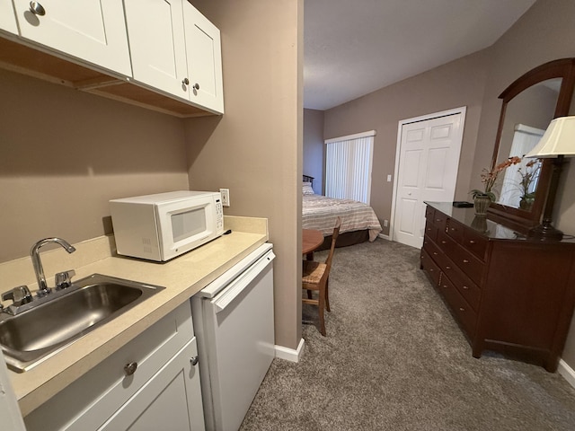 laundry area featuring dark carpet and sink